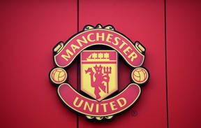 In this file photo taken on November 23, 2022 a Manchester United logo is pictured outside of Old Trafford stadium, home ground of Manchester United football team, in Manchester, northern England. (Photo by OLI SCARFF/AFP via Getty Images)