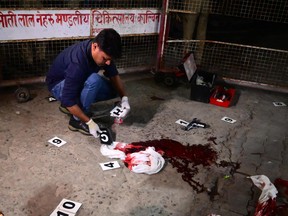 Forensic team members search for evidence at the spot where gangster-turned-politician Atiq Ahmad and his brother Ashraf Ahmad were shot dead by unidentified assailants outside Kalvin hospital while being taken for a medical checkup in police custody, in Prayagraj, on April 15, 2023.