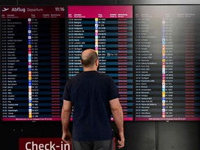 A man stands in front of a digital board showing all cancelled flights at the main terminal of the BER Berlin Brandenburg airport as departing flights were cancelled due to a strike by security workers on April 24, 2023 in Schoenefeld near Berlin, eastern Germany.