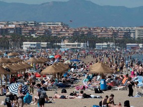 People sunbath on Malavarrosa beach in Valencia on April 24, 2023 as Spain is bracing for an early heat wave.