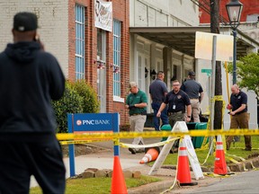 Law enforcement officers walk through the crime scene, a day after a shooting at a teenager's birthday party in a dance studio in Dadeville, Ala., April 16, 2023.
