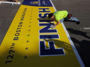 Workers prepare the finish line for the 127th running of the Boston Marathon, also the tenth anniversary of the 2013 Boston Marathon bombings, in Boston, Massachusetts, April 13, 2023.