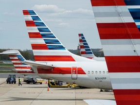 A member of a ground crew walks past American Airlines planes parked in Washington, April 5, 2020.