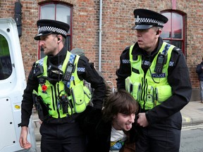 Police officers carry a man who threw an egg at King Charles into a police van during the king's visit to Micklegate bar in York, Britain November 9, 2022.