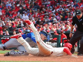 Danny Jansen #9 of the Toronto Blue Jays tags Nolan Gorman #16 of the St. Louis Cardinals for an out in the sixth inning at Busch Stadium on Saturday.