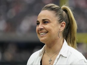 Las Vegas Aces coach Becky Hammon stands on the field before of an NFL football game between the Denver Broncos and Las Vegas Raiders, Sunday, Oct. 2, 2022 in Las Vegas.