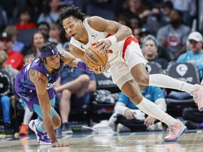 Raptors' Scottie Barnes, (right) beats Charlotte Hornets forward Xavier Sneed to a loose ball during the second half  in Charlotte, N.C., Sunday, April 2, 2023. Toronto won 128-108.