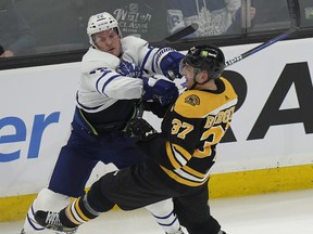 Maple Leafs defenceman Jake McCabe (left) collides with Bruins' Patrice Bergeron during the second period in Boston on Thursday, April 6, 2023.