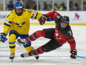 Canada forward Laura Stacey is sent flying by Sweden forward Sofie Lundin during their quarterfinal at the IIHF women's  world hockey championship in Brampton on Thursday, April 13, 2023.