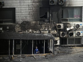 Investigators inspect burnt out corridor following a fire at a hospital in Beijing, Wednesday, April 19, 2023. More than a dozen people have died in a fire at the Beijing hospital that forced the evacuation of dozens of patients on Tuesday, Chinese state media reported.