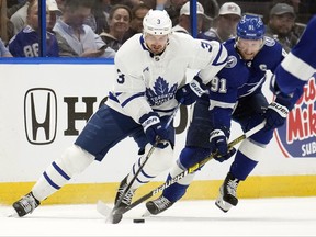 Toronto Maple Leafs defenseman Justin Holl moves the puck ahead of Tampa Bay Lightning center Steven Stamkos during the first period in Game 3 of an NHL hockey Stanley Cup first-round playoff series Saturday, April 22, 2023, in Tampa, Fla. (/)