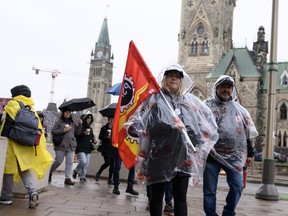 Members of the Public Service Alliance of Canada (PSAC) walk in the rain on a picket line outside the Office of the Prime Minister and Privy Council, across from Parliament Hill, as workers from Canada's largest federal public-service union are on strike across the country in Ottawa on Monday, April 24, 2023.