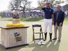 Corey Conners of Canada puts on cowboy boots after winning the Valero Texas Open at TPC San Antonio on Sunday.