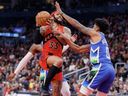 Raptors' Gary Trent Jr., left, drives to the net against MarJon Beauchamp of the Bucks during first half NBA action at Scotiabank Arena in Toronto, Sunday, April 9, 2023.
