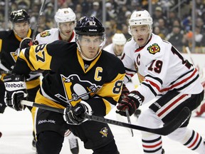 Sidney Crosby of the Pittsburgh Penguins tries to pull away from Jonathan Toews  of the Chicago Blackhawks.