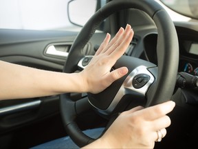 Closeup of annoyed woman driving car and honking