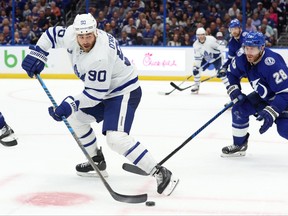 Apr 11, 2023; Tampa, Florida, USA; Toronto Maple Leafs center Ryan O'Reilly passes the puck as Tampa Bay Lightning defenseman Ian Cole attempted to defend during the second period at Amalie Arena.