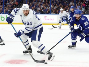 Apr 11, 2023; Tampa, Florida, USA; Toronto Maple Leafs center Ryan O'Reilly (90) passes the puck as Tampa Bay Lightning defenseman Ian Cole (28) attempted to defend during the second period at Amalie Arena.