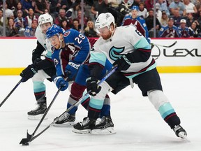 Seattle Kraken defenceman Adam Larsson (6) steals the puck away from Colorado Avalanche centre Nathan MacKinnon (29) in the second period at Ball Arena.