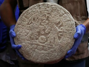 A worker shows a circular-shaped Mayan scoreboard used for a ball game found at Chichen Itza's archaeological site during a news conference, in Merida, Mexico April 11, 2023.