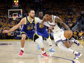 Malik Monk, right, of the Sacramento Kings is guarded by Stephen Curry of the Golden State Warriors in the second half of Game 6  of the Western Conference First Round Playoffs at Chase Center on April 28, 2023 in San Francisco, Calif.