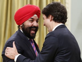 Canada's new Innovation, Science and Economic Development Minister Navdeep Bains (L) is congratulated by Prime Minister Justin Trudeau at Rideau Hall in Ottawa November 4, 2015.  AFP PHOTO/POOL/CHRIS WATTIE/Getty Images
