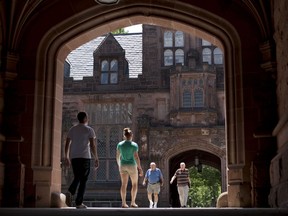 Pedestrians walk through arches of the East Pyne building on the Princeton University campus in Princeton, N.J., on  June 21, 2010.