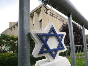 A Star of David hangs from a fence outside the dormant landmark Tree of Life synagogue in Pittsburgh's Squirrel Hill neighborhood on Tuesday, Oct. 26, 2021.