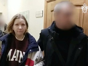 Darya Trepova, suspected of bringing explosives to the cafe where war blogger Vladlen Tatarsky (real name Maxim Fomin) was killed in an explosion, is escorted inside the building of Russian Investigative Committee, in Saint Petersburg, Russia, in this still image taken from video released on April 3, 2023.