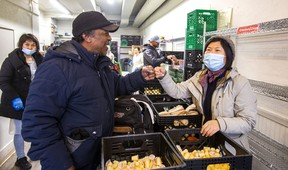 Fort York Food Bank client Vernon Harris talks with volunteer Xin Yue at 380 College St. in Toronto on Wednesday, April 5, 2023.