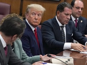 Former U.S. president Donald Trump sits with his attorneys inside the courtroom during his arraignment at the Manhattan Criminal Court April 4, 2023 in New York City.