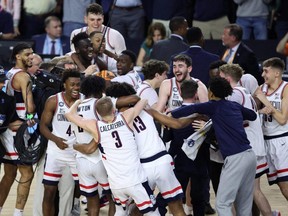 Connecticut Huskies players celebrate after defeating the San Diego State Aztecs in the national championship game of the 2023 NCAA Tournament at NRG Stadium in Houston, Monday, April 3, 2023.