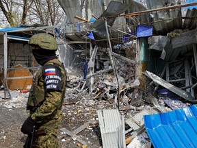 A member of the Russian Investigative Committee stands at the scene of recent shelling at a local market in the course of Russia-Ukraine conflict, in Donetsk, Russian-controlled Ukraine, April 7, 2023.