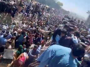 People are crowded before Thursday's attack, along a canal near the Abbey Gate at Kabul's airport, Afghanistan Aug. 26, 2021 in this still grab obtained by REUTERS from a video.