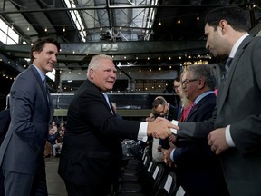 Prime Minister Justin Trudeau and Ontario Premier Doug Ford arrive to attend a news conference to announce details on the construction of a gigafactory for electric vehicle battery production by Volkswagen Group's battery company PowerCo SE in St. Thomas, Ontario April 21, 2023.