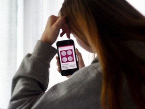 In this file photo illustration taken on May 8, 2020, a woman looks at website with the Mifepristone Abortion Pill on her smart phone in Arlington, Va.