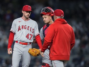 Los Angeles Angels starting pitcher Griffin Canning, left, waits with catcher Matt Thaiss as manager Phil Nevin comes to remove Canning during the sixth inning of the team's baseball game against the New York Yankees on Wednesday, April 19, 2023, in New York.