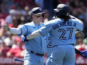 Toronto Blue Jays' Matt Chapman, left, is hugged by Vladimir Guerrero Jr. (27) after Chapman's grand-slam during the sixth inning of a baseball game Los Angeles Angels, in Anaheim, Calif., Sunday, April 9, 2023. Chapman has been named American League player of the week.