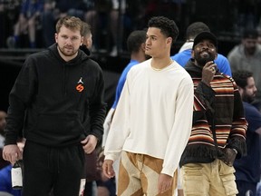Dallas Mavericks' Luka Doncic, left, Josh Green, centre, and Kyrie Irving, right, stand on the court during a timeout in the second half of an NBA basketball game against the Chicago Bulls, Friday, April 7, 2023, in Dallas.