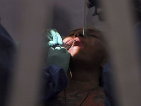 A dentist works on a patient on Monday, July 26, 2021, in San Juan, Texas.