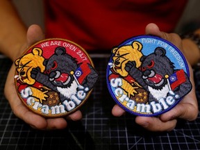 Alec Hsu shows to the camera patches depicting a Formosan black bear holding Taiwan?s flag and punching Winnie the Pooh at his store in Taoyuan, Taiwan April 10, 2023.
