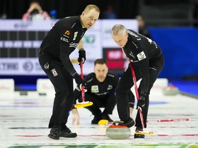 Canadian lead Geoff Walker, left, and Canadian second EJ Harnden sweep as Canadian skip Brad Gushue looks on while playing Japan at the Men's World Curling Championship in Ottawa on Monday, April 3, 2023.
