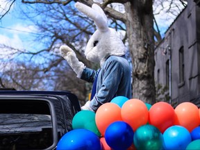 Side view of Easter Bunny in blue suit waving.