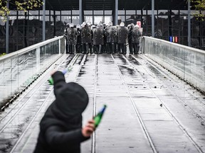 A protester throws a bottle towards riot police during a demonstration in Nantes, western France on April 13, 2023.