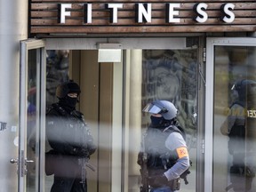 Armed police officers stay in front of a health club in Duisburg, Germany, Tuesday, April 18, 2023. German news agency dpa is quoting police as saying several people have been injured in an attack at a gym in Duisburg.
