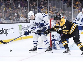 Apr 6, 2023; Boston, Massachusetts, USA; Toronto Maple Leafs defenseman Luke Schenn (2) and Boston Bruins center Charlie Coyle (13) battle for the puck during the third period at TD Garden.