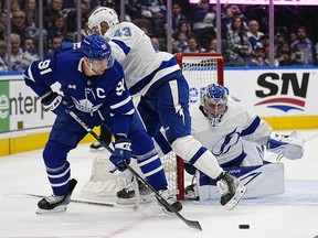 Apr 18, 2023; Toronto, Ontario, CAN; Toronto Maple Leafs forward John Tavares tries to center the puck in front of the Tampa Bay Lightning goaltender Andrei Vasilevskiy as he is hit by defenseman Darren Raddysh during the first period of game one of the first round of the 2023 Stanley Cup Playoffs at Scotiabank Arena.
