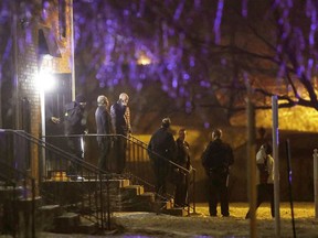 Officers walk out of the apartment complex where four people, one woman and three men, were found dead in Indianapolis, Feb. 5, 2020.
