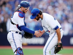 Jordan Romano (right) of the Toronto Blue Jays is congratulated by Danny Jansen after getting the final out of the game against the Tampa Bay Rays at Rogers Centre on April 15, 2023 in Toronto.