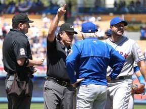 New York Mets starting pitcher Max Scherzer (21) is ejected by first base umpire Phil Cuzzi (10) as home plate umpire Dan Bellino (2) and manager New York Mets manager Buck Showalter (11) watch in the fourth inning against the Los Angeles Dodgers at Dodger Stadium.